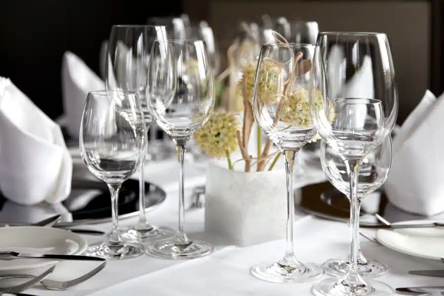 Empty glasses on dinner table with set places