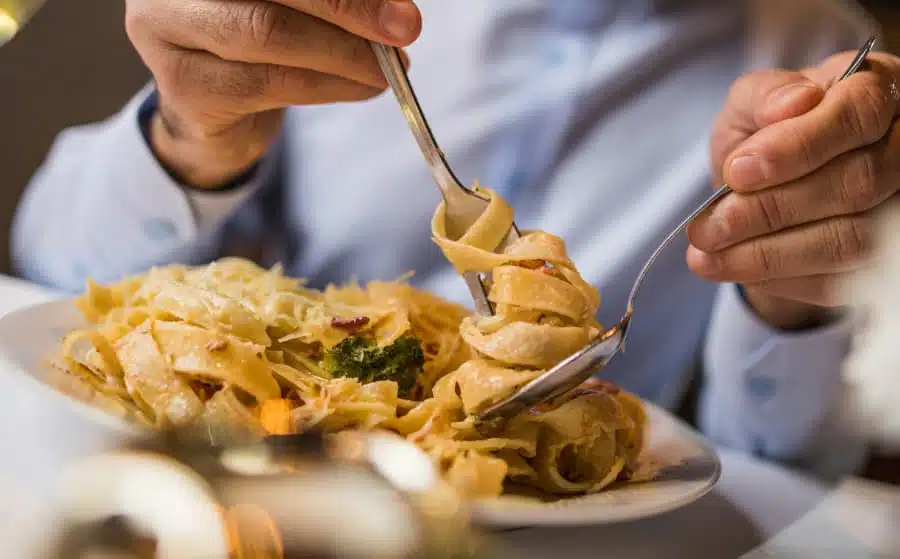 Customer twirling pasta noodles with fork