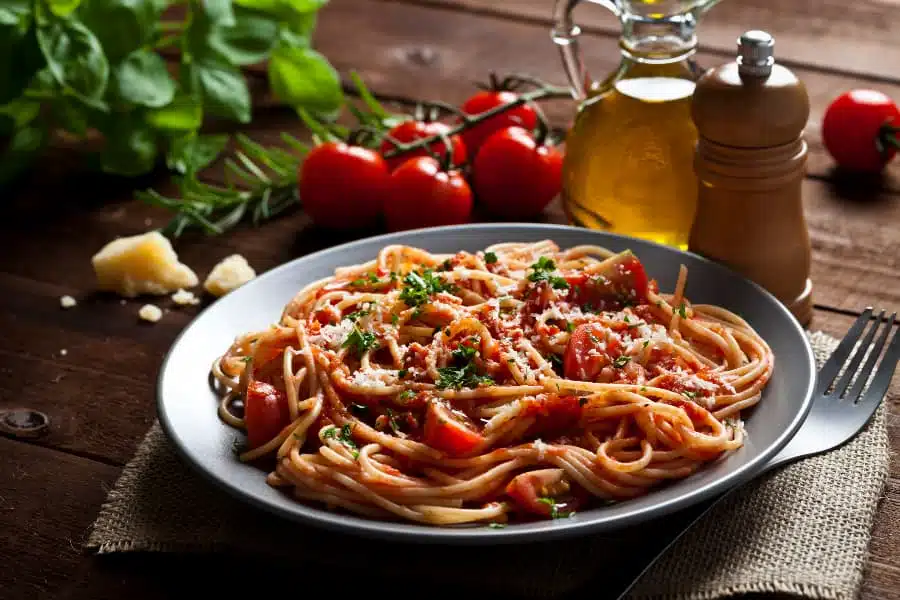 Pasta with tomato sauce on rustic wood table